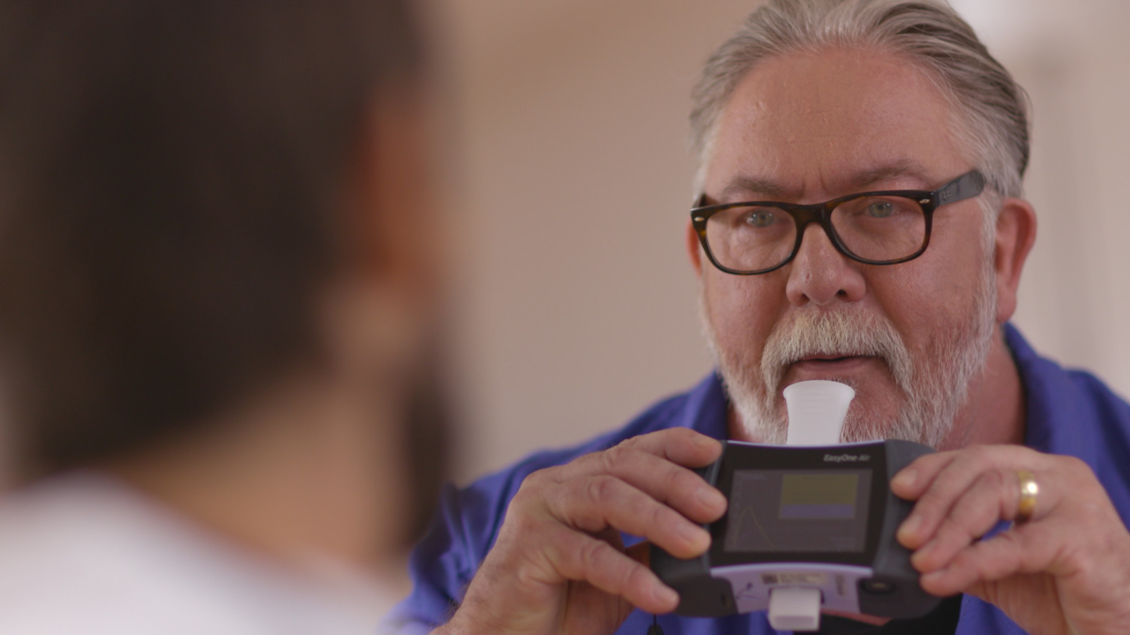 Older man holding an EasyOne Air spirometer